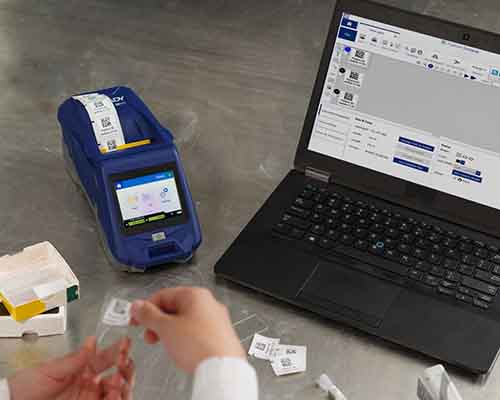 Osoba aplikujúca štítok vytlačený na tlačiarni M611 na laboratórne sklíčko.